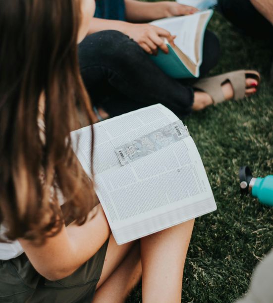 Teenagers participating in a Bible study discussion with a youth leader